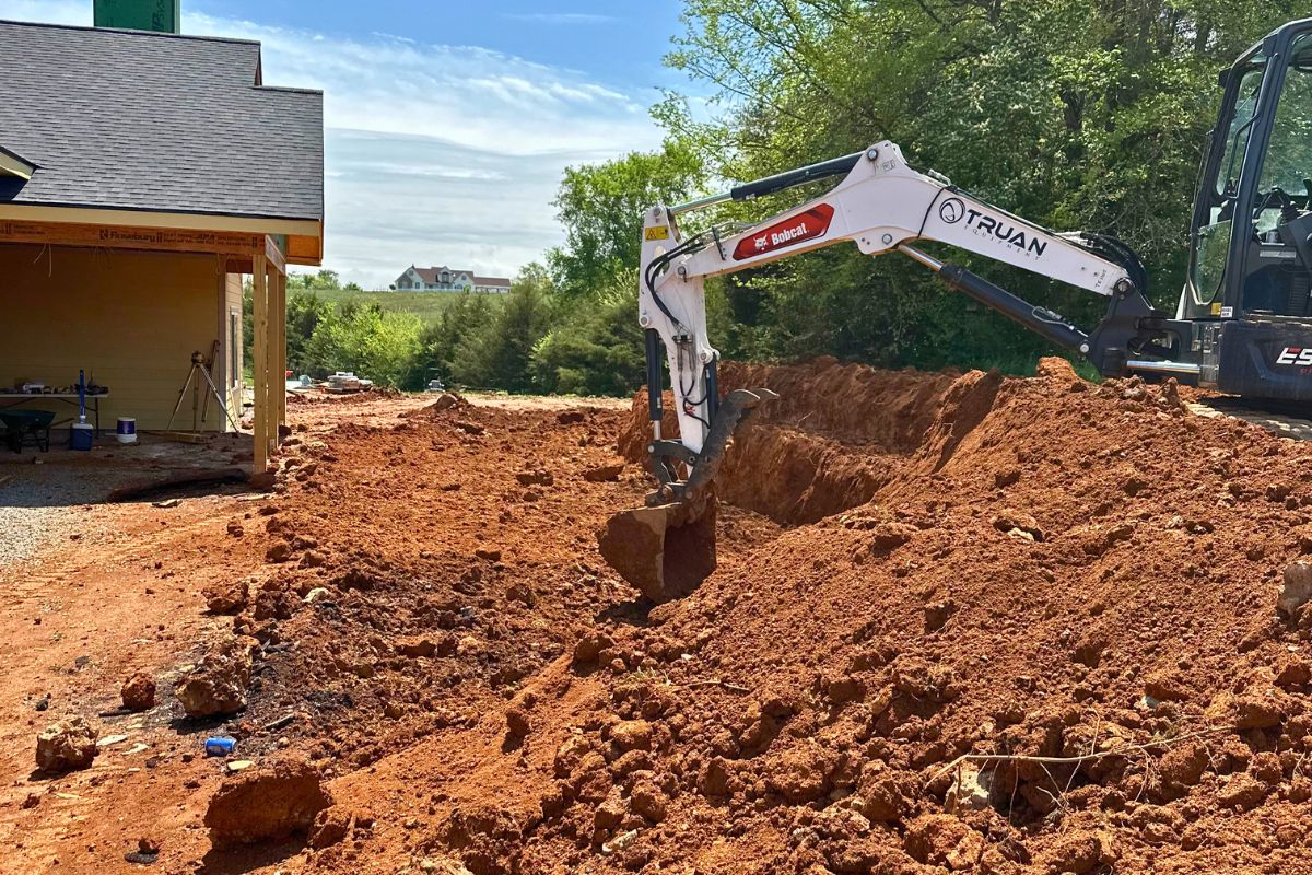 excavator digging land in backyard